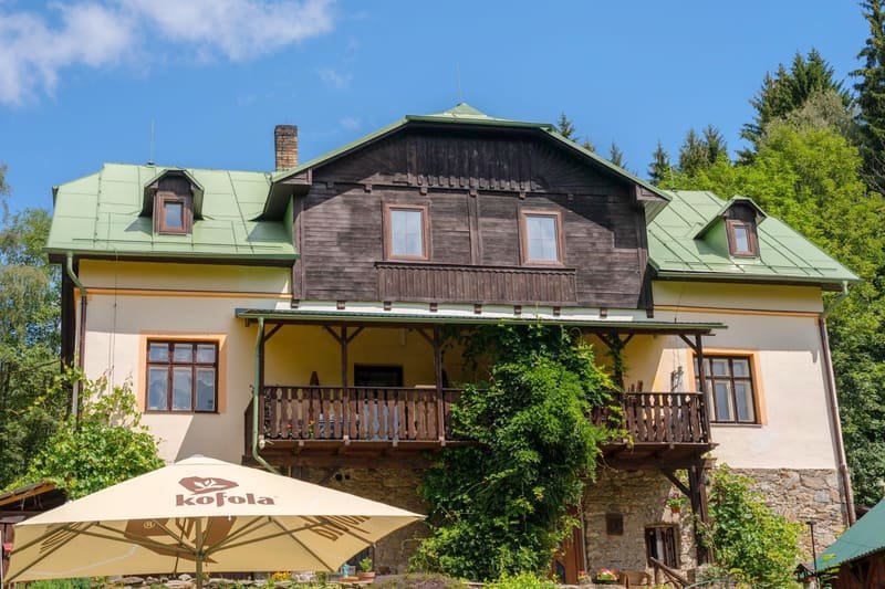 Historická budova penzionu HamrákOFF se zelenou střechou